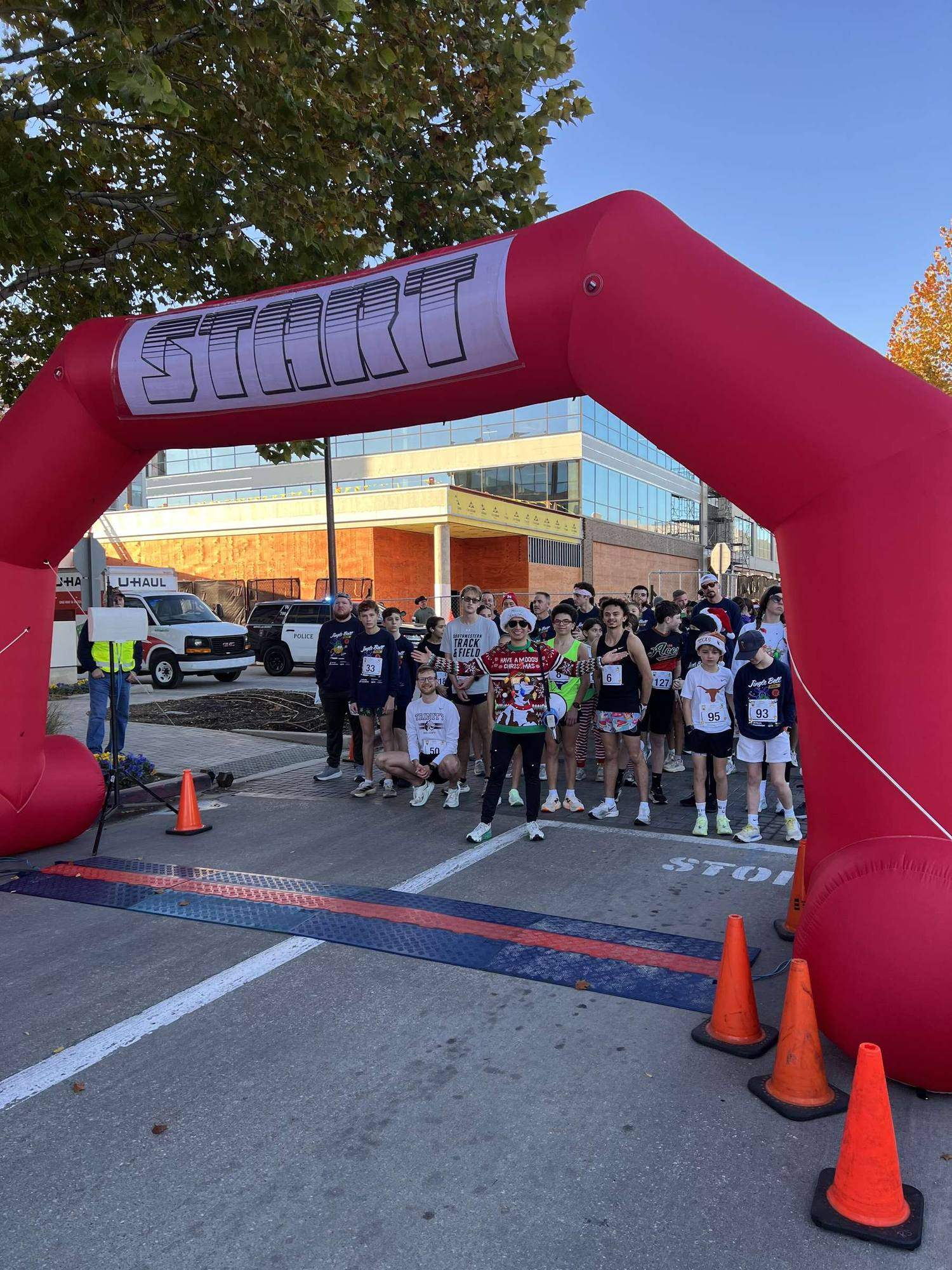 Runners gathered under the start arch at a RUNROO race