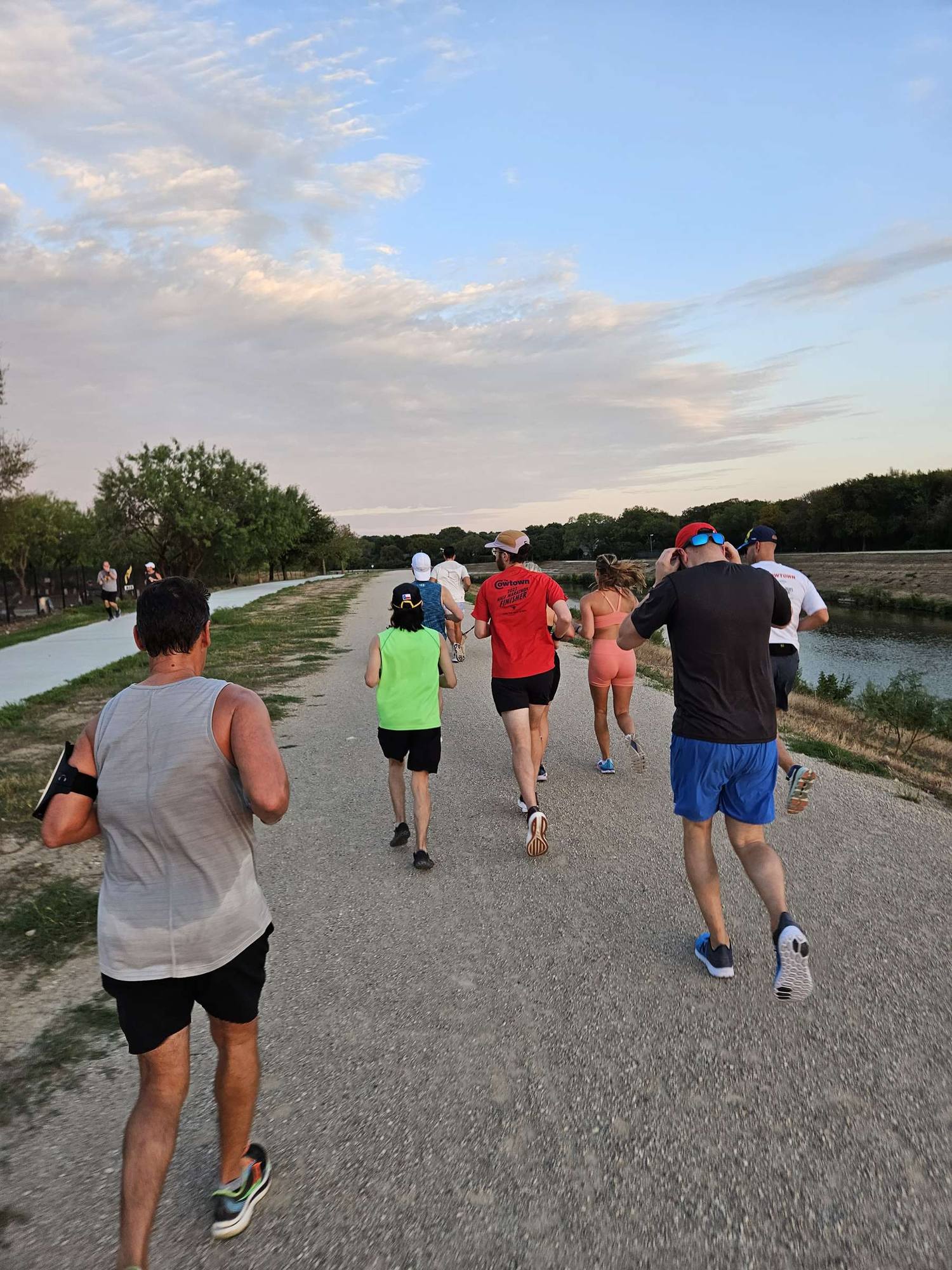 Runners heading down the riverside path at a RUNROO event